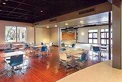 At Christ Community Church (Houston), a large fellowship room and café connects  to the main entry lobby. A moveable glass wall is used to close the room during  classes or lectures but can be entirely opened up to create a large lobby space  or banquet set-up. The reclaimed wood wall in the background leads visitors into  the church Worship Center. (Photo by: Gary Zvonkovic)
